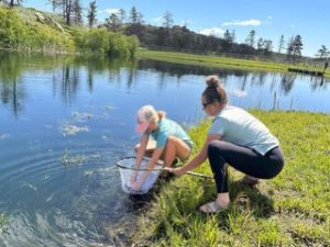 Lilli in the process of mentoring a young girl in fly fishing at the PEAK Fish Camp.